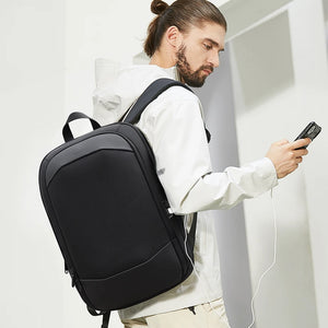Black travel backpack worn on the back with padded shoulder straps and top handle