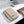 Beige laptop bag closed with front zipper pocket and top handle