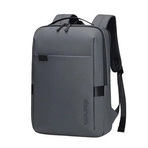 Grey waterproof travel backpack with front pocket, top handle, and side strap