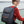 Black commuter backpack with top flap, front organizer pocket, and adjustable straps