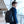 Black waterproof travel backpack worn by a man, with top handle and front pockets
