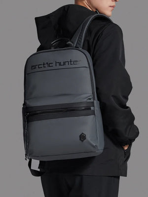 Person wearing a gray backpack with 'arctic hunter' branding on a gray background
