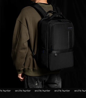 Black waterproof travel backpack worn on back with front zipper panel