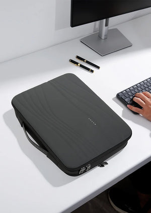 Black padded laptop sleeve on desk with zipper and quilted wave texture