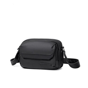 Black waterproof crossbody bag with flap front, zip top, and adjustable shoulder strap
