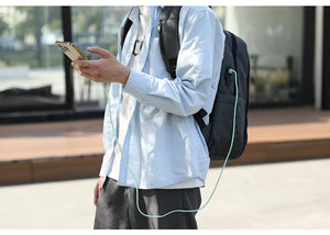 Grey backpack with USB charging cable connected from the side