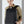Black waterproof travel backpack with top handle and front zipper, worn by person