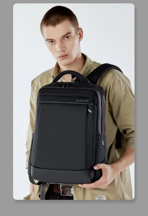 Black waterproof travel backpack with top handle and front zipper, worn by person