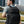 Black waterproof backpack worn on back with adjustable shoulder straps and top handle.