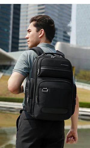 Black waterproof backpack worn on back with adjustable shoulder straps and top handle.