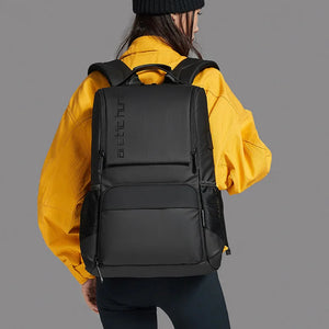 Black travel backpack with top handle, front zip pockets, and adjustable shoulder straps