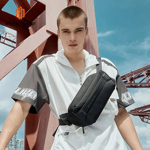 Black crossbody bag worn across torso; padded body with front zip and adjustable strap.