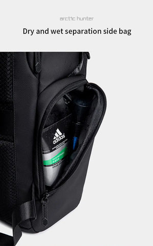 Black waterproof travel backpack with zipped side pocket and visible USB charging port