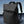 Black backpack with top handle and curved shoulder straps, shown angled on display.