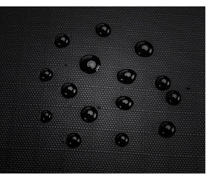 Waterproof backpack fabric with visible raindrop droplets on black textured surface