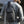Black crossbody sling bag worn on back, with top handle and front organizer pockets.