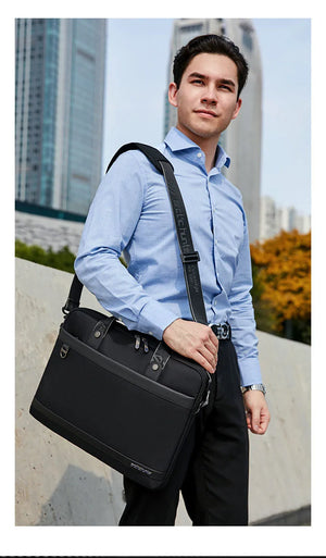 Black waterproof laptop bag with shoulder strap and front zipper pocket
