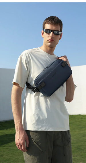 Blue lightweight waterproof crossbody bag worn with adjustable strap and top zipper.