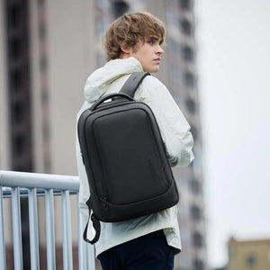 Waterproof travel backpack worn on back, black exterior with front zipper pocket