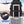 Black backpack placed on rolling suitcase with front opening accessory and anti-theft design