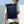 Navy blue roll-top backpack with front zip pockets and padded shoulder straps