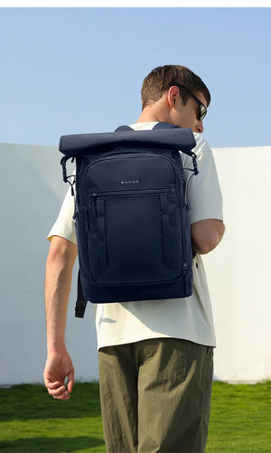 Navy blue roll-top backpack with front zip pockets and padded shoulder straps