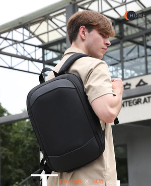 Black travel backpack with top handle and adjustable shoulder straps, worn in transit