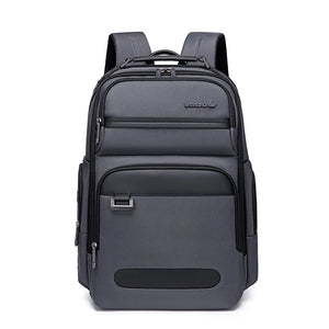 Grey waterproof travel backpack with front pocket, top handle, and padded straps