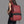 Red travel backpack with front zip pocket, black trim, and padded shoulder straps
