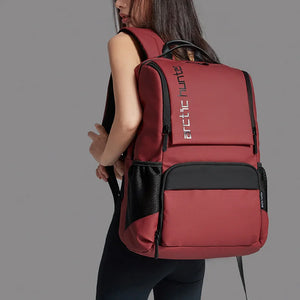 Red travel backpack with front zip pocket, black trim, and padded shoulder straps