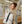 Beige compact commuter backpack with top handle and front buckle straps