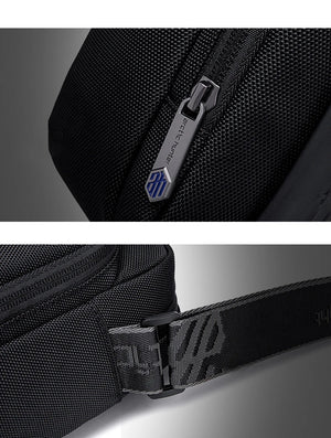 Black textured compact messenger bag close-up of zipper pull and logo badge