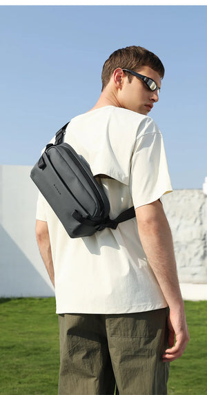 Waterproof crossbody bag worn across the back in dark gray with adjustable strap