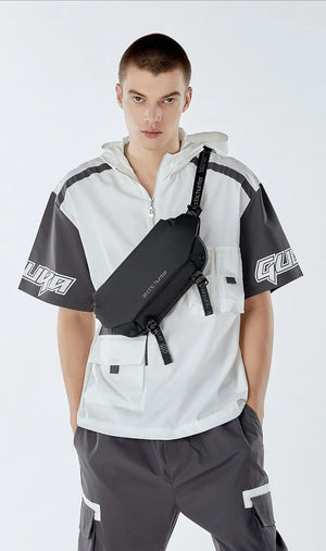 Black crossbody sling bag worn with front zip pocket and adjustable strap