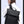 Black backpack worn by a person from the side, with front zip pocket and straps.