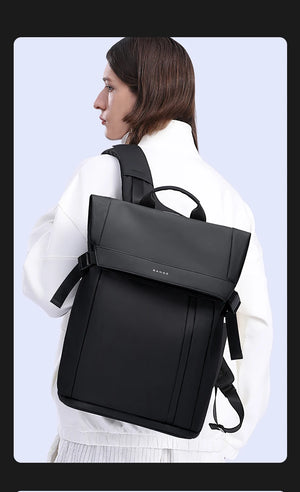 Black backpack worn by a person from the side, with front zip pocket and straps.
