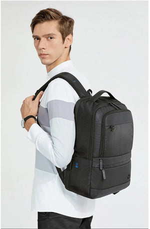 Black backpack worn on shoulders with padded straps and front zip pocket