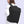 Black travel backpack on a person from side view with front zip pocket and shoulder strap