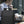 Black travel backpack worn by person beside laptop in an office setting