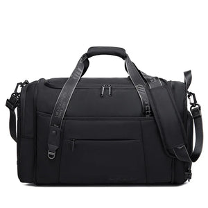 Black waterproof duffel bag with top handle, shoulder strap, and multiple zip pockets.