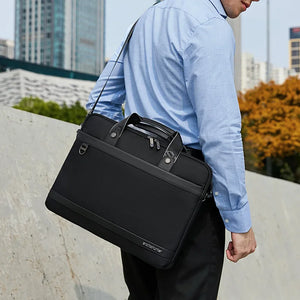 Black waterproof laptop bag on shoulder strap, front pocket with metal zipper