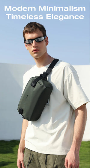 Minimalist sling bag worn across the chest with dark green adjustable strap