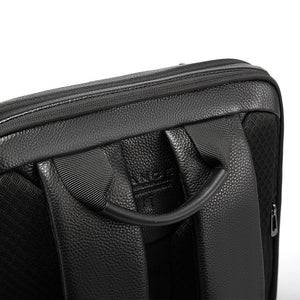Black backpack front panel close-up with embossed logo and curved carry strap